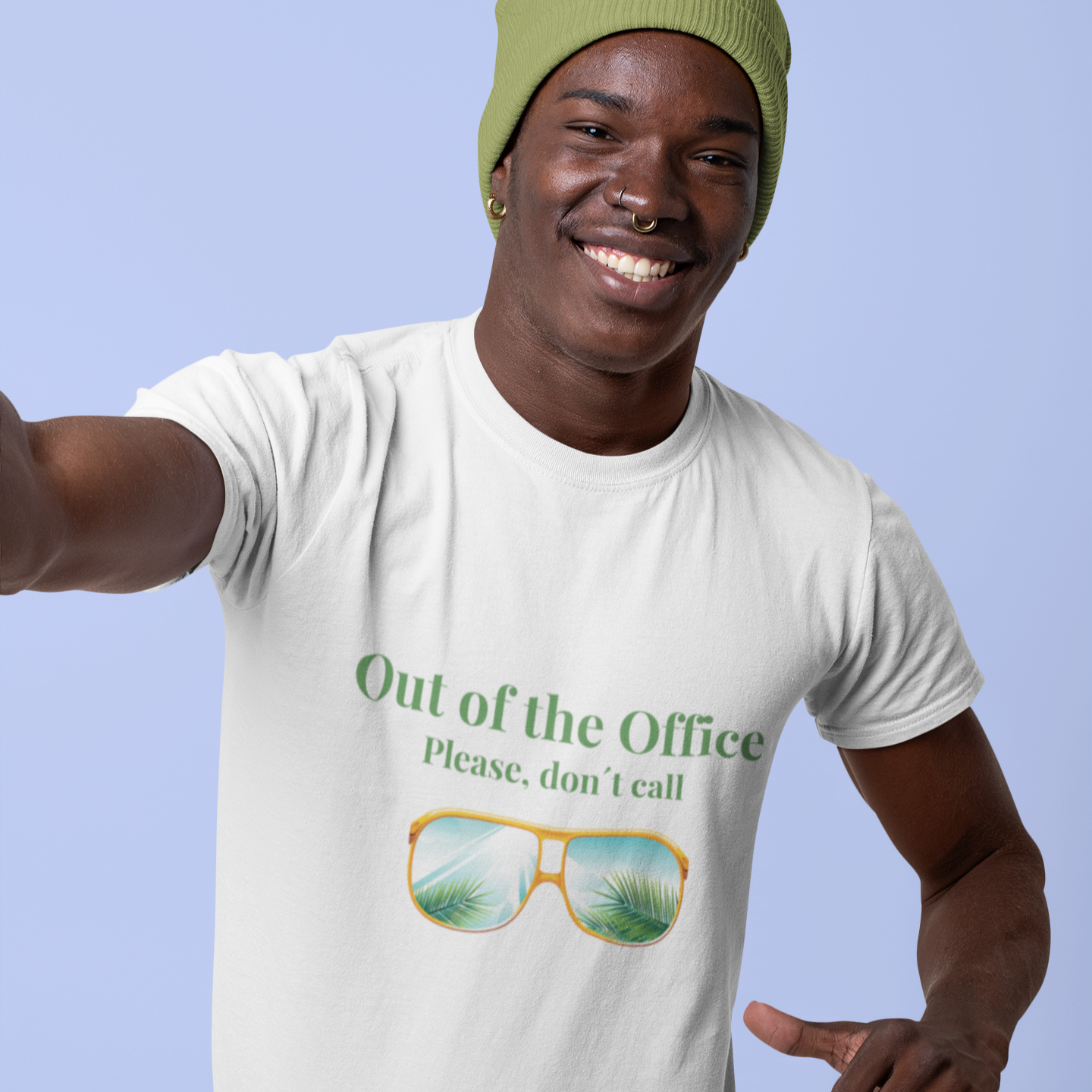 Person wearing a white t-shirt with sunglasses graphic and text, pointing to the camera against a light blue background